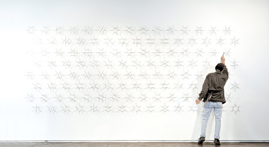 Edward Tufte makes an adjustment to one of his large-scale pieces based on Feynman diagrams.