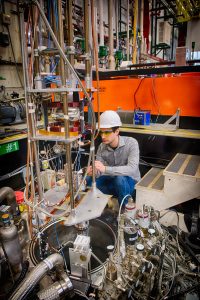Sam Posen sets up a superconducting accelerating cavity in a vertical test stand. Photo: Reidar Hahn