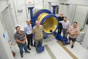 Members of the Fermilab team stand with the lens-holding barrel for the Dark Energy Spectroscopic Instrument. From left: Jorge Montes, Mike Roman, David Butler, Gaston Gutierrez, Giuseppe Gallo and Otto Alvarez. Photo: Reidar Hahn