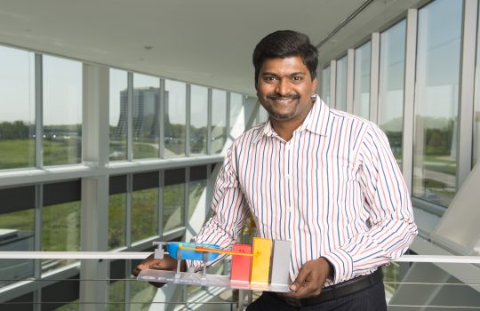 Charles Thanagaraj holds a model of the compact accelerator he recently received a grant to develop. Photo: Reidar Hahn