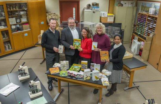 In the spirit of the season, the not-for-profit organization Fermilab Natural Areas presented the Lederman Science Center at Fermilab with an early gift. FNA, represented by President Penny Kasper (center) and Vice President Liz Copeland (second from right), donated a selection of environmental education books and field guides in English and Spanish to the center. The donation was made possible with a grant from the Nature Conservancy’s Volunteer Stewardship Network. Fermilab Chief Operating Officer Tim Meyer (left), Fermilab Office of Education and Public Outreach Manager Spencer Pasero and Fermilab Chief of Staff Hema Ramamoorthi received the gift on behalf of Fermilab. Photo: Fermilab