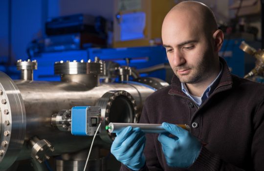 David Flay holds one of the sensors that Muon g-2 scientists will use to map the magnetic field inside the experiment's storage ring. Photo: Reidar Hahn