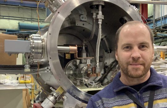 Fermilab scientist Juan Estrada stands in front of the Oscura test vessel for the operation of CCDs in liquid nitrogen. OSCURA, people, dark matter Photo: Andrew Lathrop