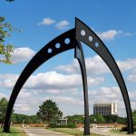 The giant Broken Symmetry sculpture stands over the road into Fermilab's Batavia campus