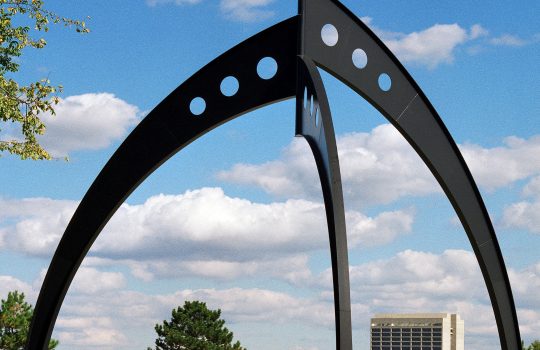 The giant Broken Symmetry sculpture stands over the road into Fermilab's Batavia campus