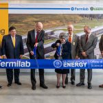 Deputy Secretary of Energy David Turk and Fermilab Director Lia Merminga cut a large ribbon with oversized ceremonial scissors while other people look on