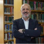 Portrait of Stefano Miscetti with library shelves behind him.