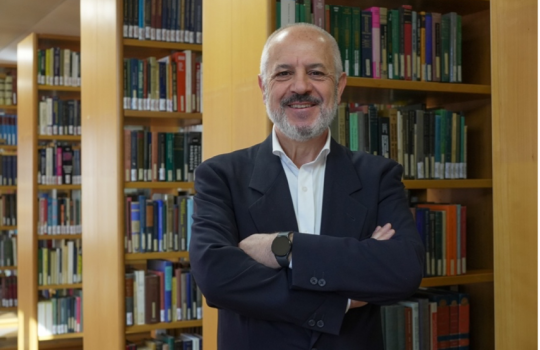 Portrait of Stefano Miscetti with library shelves behind him.