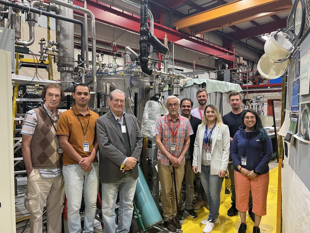 Researchers from Fermilab and Brazil pose with the ICEBERG test stand at Fermilab to commemorate the testing of a new filter technology for removing nitrogen from liquid argon. From left: Helio Da Motta, Daniel Souza Correia, Dilson Cardoso, Carlos Escobar, Pascoal Pagliuso, Sergey Koshelev, Roza Doubnik, Robert Mrowca and Flor de Maria Blaszczyk. Photo: Courtesy of Roza Doubnik