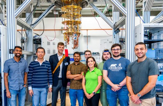Photo taken at SQMS Quantum Garage at Fermilab. Pictured L-R: Akshay Murthy, associate scientist at Fermilab; Yao Lu, associate scientist at Fermilab; Jason Orcutt, principal research scientist at IBM; Tanay Roy, associate scientist at Fermilab; Andre Vallieres, PhD student at Northwestern University; Silvia Zorzetti, department head, quantum computing co-design and communication at Fermilab; Jacob Hanson-Flores, summer intern at Fermilab; Alessandro Reineri, PhD student at Illinois Institute of Technology; Joey Yaker, PhD student at Northwestern University. (Credit: Dan Svoboda, Fermilab)