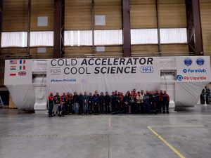 A group of people stands in front of a large and tall box