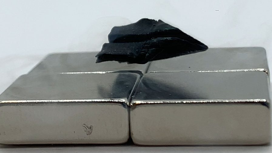 A sample of a superconductor 3D printed from a single seed — this one shaped like a paper airplane — is shown levitating over a magnet. Credit: Dingchang Zhang