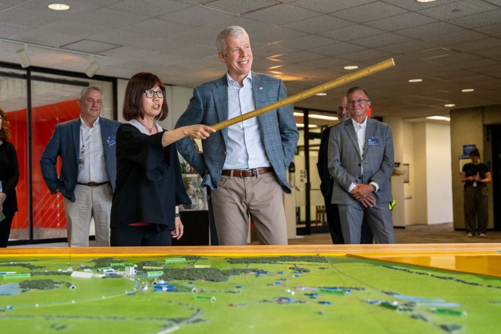 Interim Director of Fermilab, Young-Kee-Kim, (center left) shows Secretary of Energy Chris Wright (center right) the design of the Fermilab campus with the aid of a 3D map and the panoramic view to the outside from the windows on the 15th floor of the lab’s iconic Wilson Hall on July 17, 2025. Credit: Ryan Postel, Fermilab