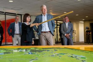 Interim Director of Fermilab, Young-Kee-Kim, (center left) shows Secretary of Energy Chris Wright (center right) the design of the Fermilab campus with the aid of a 3D map and the panoramic view to the outside from the windows on the 15th floor of the lab’s iconic Wilson Hall on July 17, 2025. Credit: Ryan Postel, Fermilab