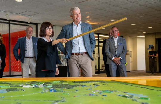 Interim Director of Fermilab, Young-Kee-Kim, (center left) shows Secretary of Energy Chris Wright (center right) the design of the Fermilab campus with the aid of a 3D map and the panoramic view to the outside from the windows on the 15th floor of the lab’s iconic Wilson Hall on July 17, 2025. Credit: Ryan Postel, Fermilab