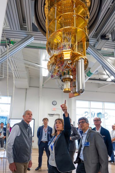 Director of the Superconducting Quantum Materials and Systems Center Anna Grassellino (center) points to superconducting quantum computing processor during a tour of SQMS for Secretary of Energy Chris Wright (left) on July 17, 2025. Credit: Ryan Postel, Fermilab