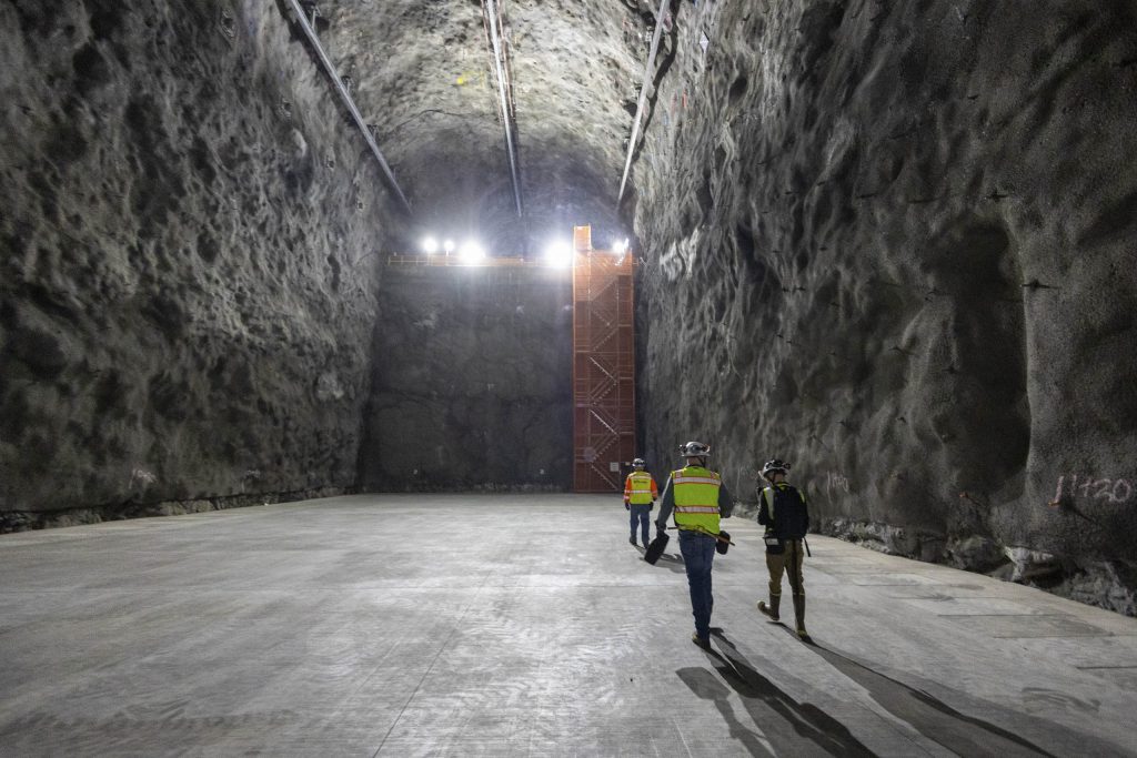 In April 2025, people walk through an LBNF/DUNE research space at the Sanford Underground Research Facility in Lead, South Dakota. Located nearly a mile below ground, this area will house a massive particle detector filled with liquid argon. Credit: Destyn Humann, Fermilab