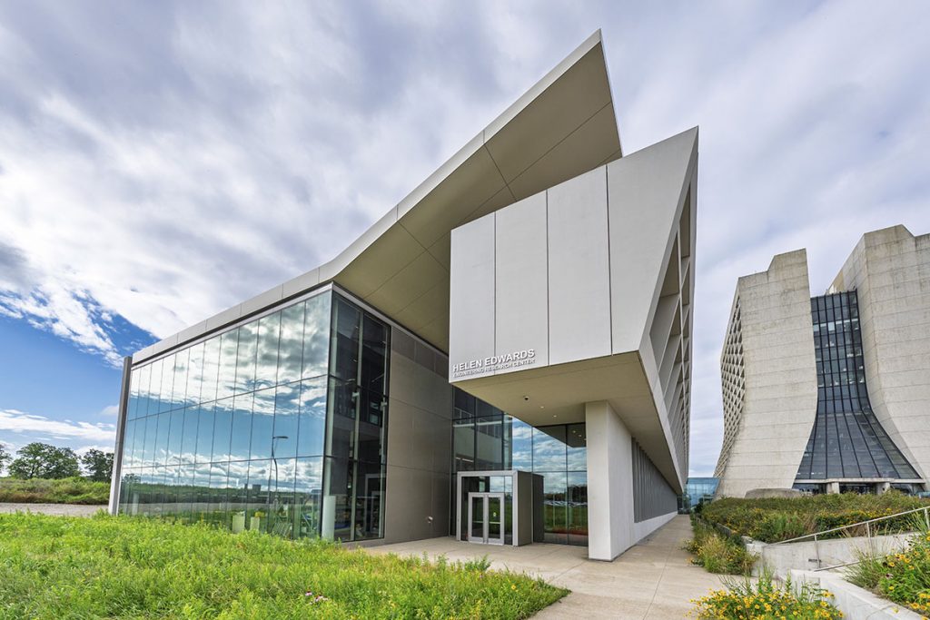 Fermilab’s new engineering research center bears the name of renowned accelerator physicist Helen Edwards, who was instrumental in building the lab’s particle accelerator complex. The new Helen Edwards Engineering Research Center at Fermilab is located next to the 16-story Wilson Hall. Credit: Ryan Posel, Fermilab