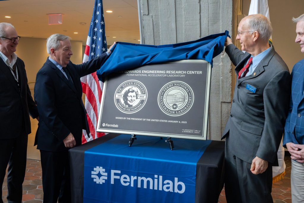U.S. Senator Dick Durbin, left, and U.S. Representative Bill Foster, right, unveil the commemorative plaque showing the late Dr. Helen Edwards and the official naming of the Helen Edwards Engineering Research Center in her honor, on Friday, Dec. 5 at Fermilab in Batavia, Illinois. Credit: JJ Starr, Fermilab