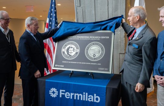 U.S. Senator Dick Durbin, left, and U.S. Representative Bill Foster, right, unveil the commemorative plaque showing the late Dr. Helen Edwards and the official naming of the Helen Edwards Engineering Research Center in her honor, on Friday, Dec. 5 at Fermilab in Batavia, Illinois. Credit: JJ Starr, Fermilab