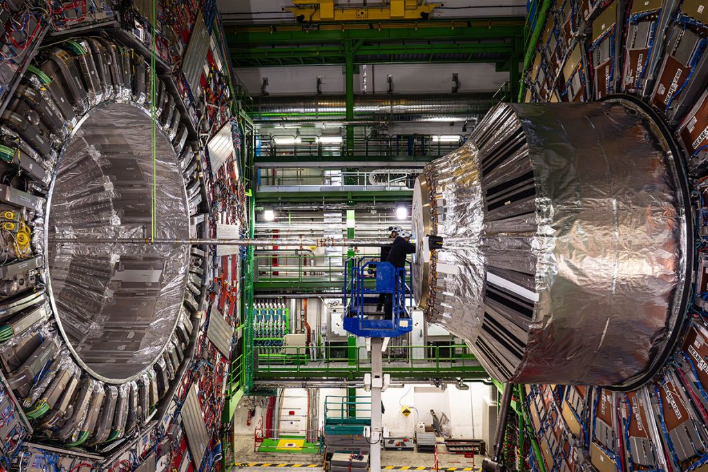A person, center, right, is dwarfed by the size of the CMS experiment at the Large Hadron Collider, shown here in 2024. Credit: CMS/CERN