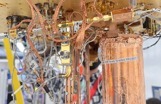 Setup of an experiment at Fermilab to test use of an ultrasensitive detector to search for evidence of dark photons, a hypothetical particle of dark matter. Housed within a dilution refrigerator kept at cryogenic temperatures, the copper wrapped mu-metal can, at right, contains the detector. Credit: Fang Zhao, Fermilab