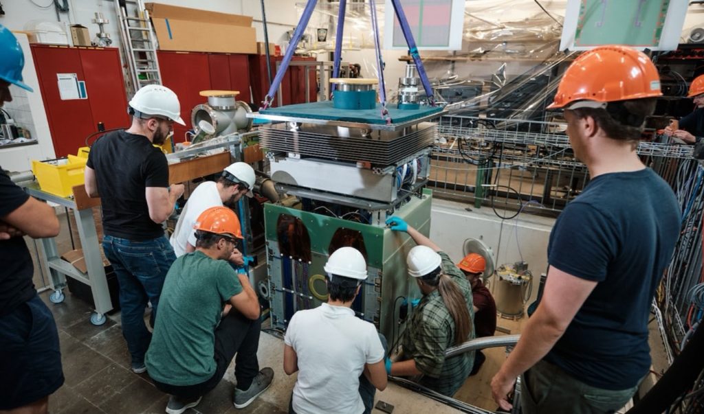 Researchers extract the full-scale demonstrator, an instrumented liquid-argon test module for the DUNE ND-LAr, out of the test cryostat at Bern following its successful data-taking. Credit: Dres Hubacher, University of Bern