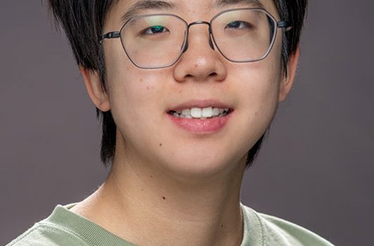 Portrait of Christina Wang, a postdoctoral researcher and Lederman Fellow at Fermi National Accelerator Laboratory, who has been awarded the American Physical Society’s 2026 Mitsuyoshi Tanaka Award in Experimental Particle Physics for her pioneering work in particle detection.