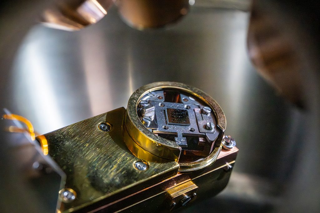 Superconducting qubit chip seen inside the X-ray photoelectron spectroscopy analysis chamber. Using XPS, researchers can understand the chemical composition of oxides present at the surface of the devices. Credit: JJ Starr, Fermilab